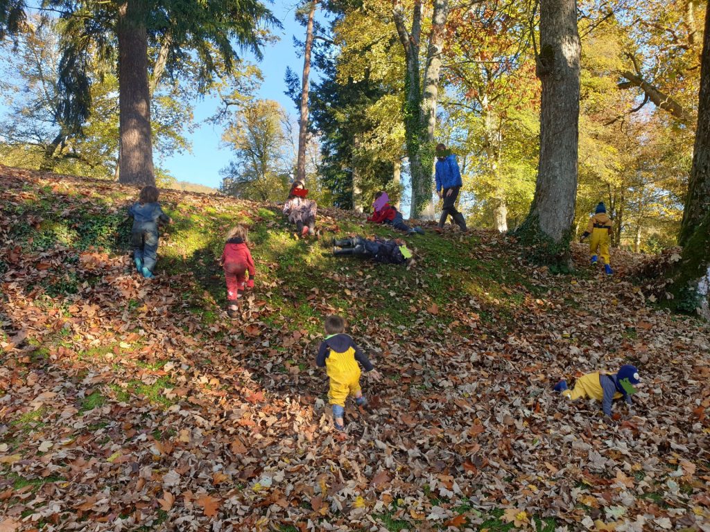 Des enfants jouent au toboggan de feuilles à Pontécoulant, Calvados