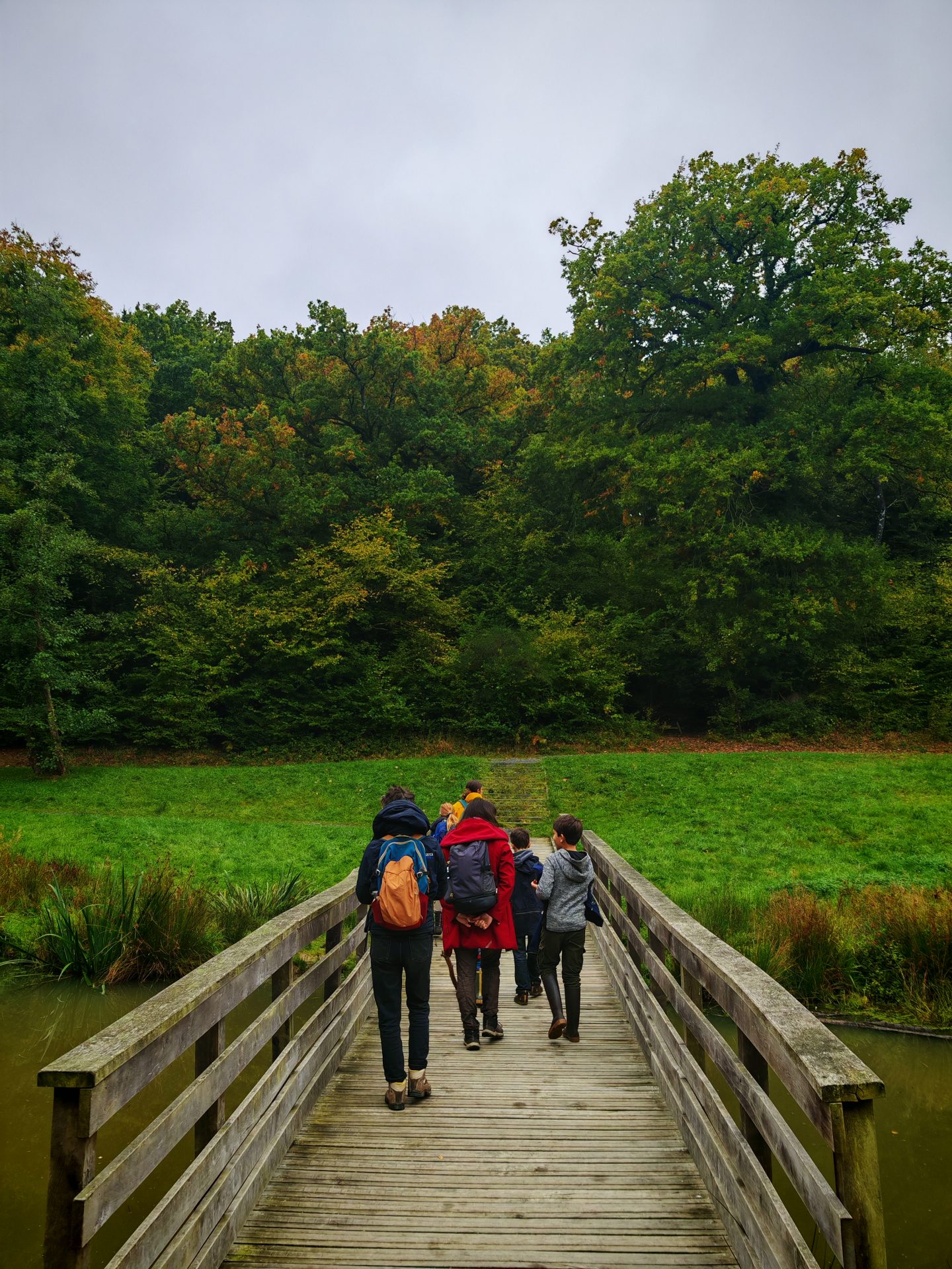Personnes traversant un pont lors d'une Marche du temps Profond à Grimbosq dans le Calvados