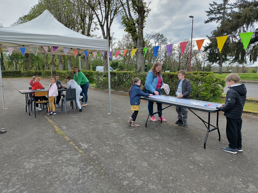Du public rassemblé autour de jeux de société lors de l'après-midi "jeux en Folie" à Condé-sur-Noireau (Calvados)